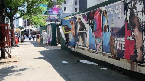 New Yorkers react to posters plastered on side of work-site walls, NYC Stock Footage 203802412