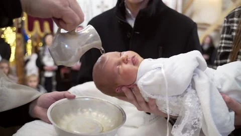 Newborn baby baptism in Holy water. Baptism in the font. Sacrament of baptism  Stock Footage