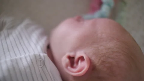 A Newborn baby in a cot close up 4K shallow focus Stock Footage 142873479