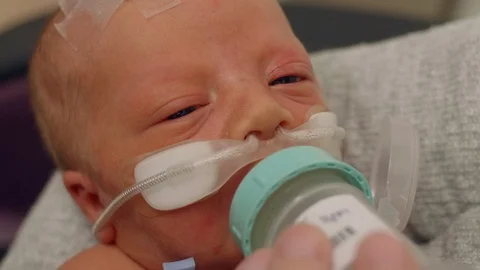 Newborn Baby Drinking from a Bottle While at the NICU While Being Held Stock Footage 91895583