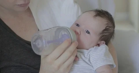 Newborn baby drinks formula from a bottle Stock Footage
