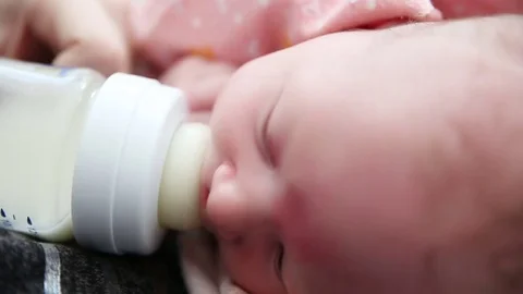 Newborn baby eats from a bottle at mom's hands Stock Footage 73326060