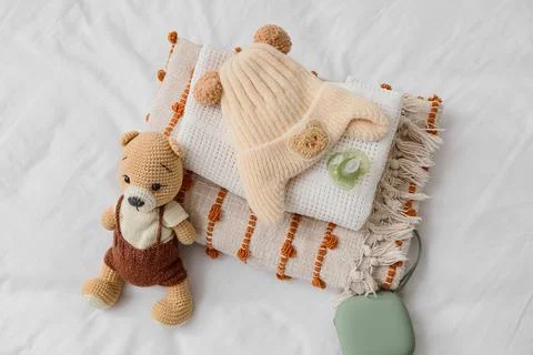 Newborn baby essentials flat lay with knitted bear toy, warm hat, soft blanke Stock Photos