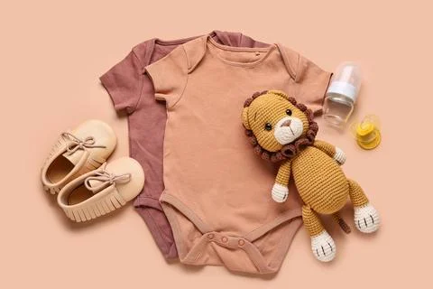 Newborn baby essentials flat lay with bodysuits, moccasins, lion toy, bottle, Stock Photos