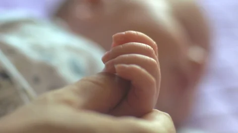 Newborn baby holding mother's hand finger Stock Footage