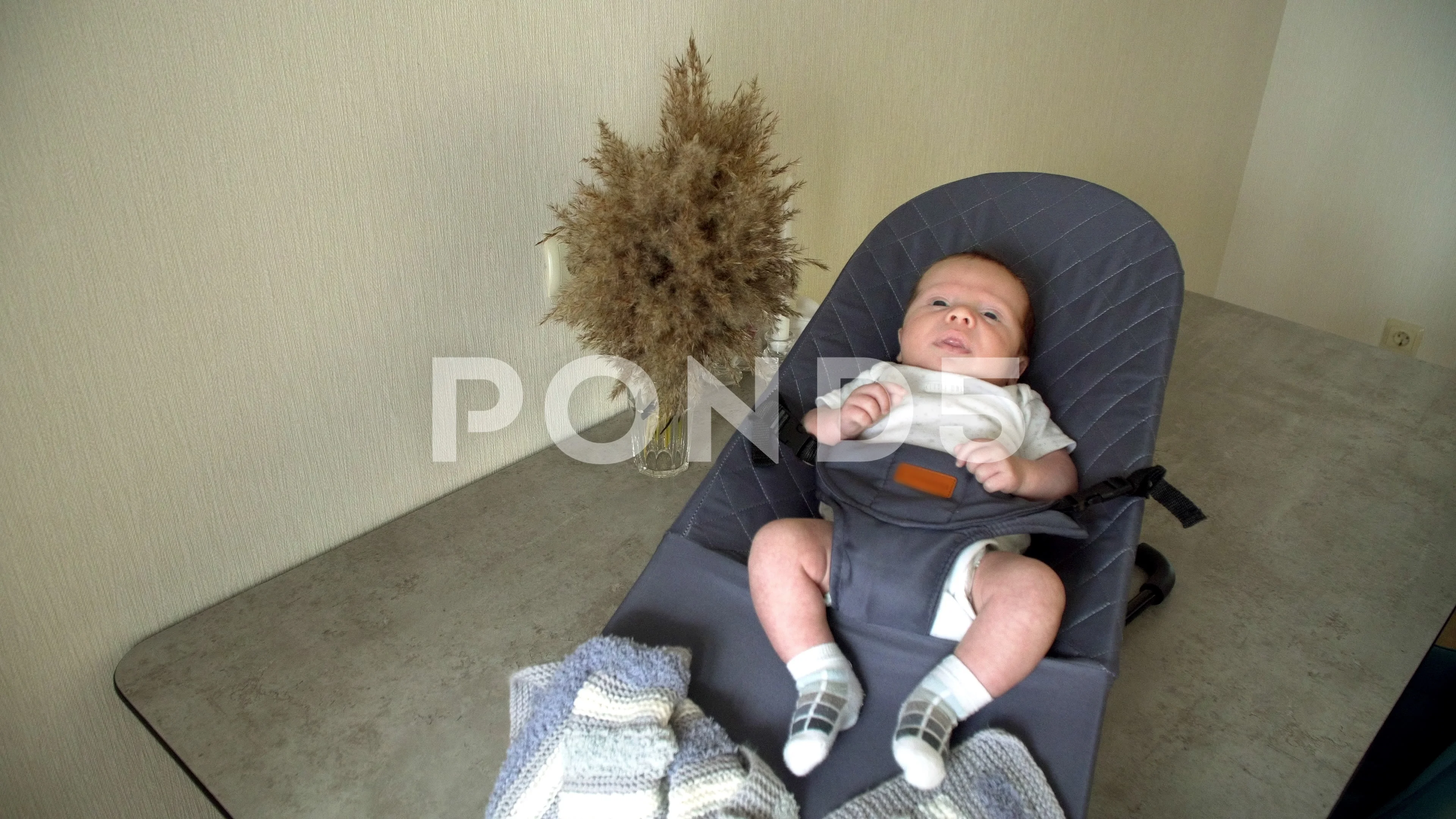 A newborn baby lies in a sun lounger