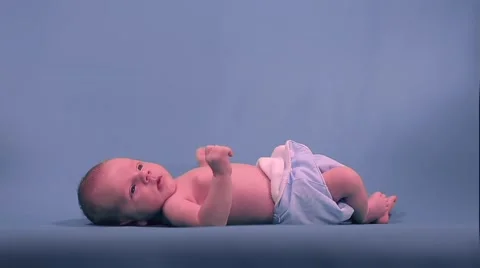 Newborn baby lying and pulling the handles on the background. Stockbeeldmateriaal 50057231