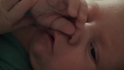 Newborn baby rubbing face with tiny hands Stock Footage 341040696