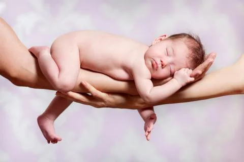 Newborn baby sleeping on parents hands Stock Photos