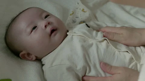 A newborn baby smiling while receiving a mother's tummy massage. Stock Footage 194709210