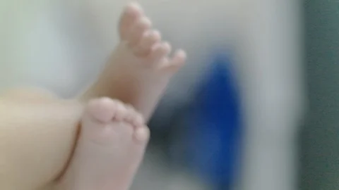 Newborn baby swing her leg in slow motion Stock Footage