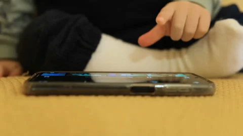 Newborn child use smartphone device alone at home,kids education technology Stock Footage 230737986