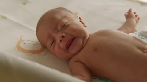 Newborn crying on bedsheet Stock Footage 337523312