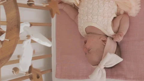 Newborn crying in a crib under mobile Stock Footage 228275788