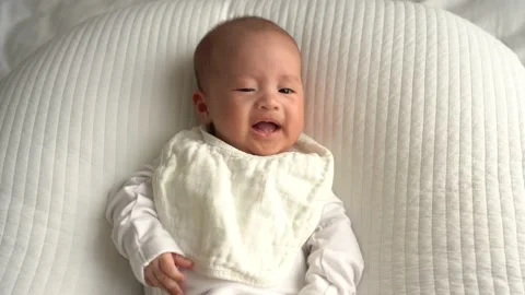 Newborn infant lying on white cushion and getting angry Stock Footage 162667930