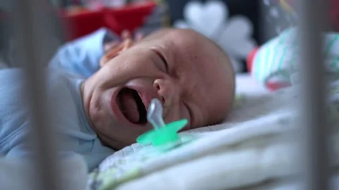 Newborn lost the pacifier and crying in his bed Stock Footage 166363669