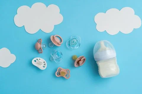 Newborn preparations: pacifiers and essentials on blue, top shot with space Stock Photos