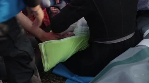 Newborn refugee being cared for after it has arrived with its family in Lesb Stock Footage 145912147