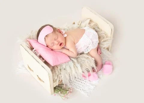 Newborn sleeping in tiny bed Stock Photos