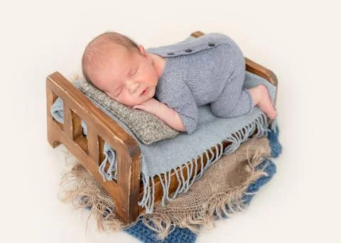Newborn sleeping on tiny bed Stock Photos