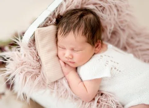 Newborn sleeping in tiny bed Stock Photos