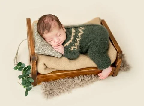 Newborn on tiny bed Stock Photos