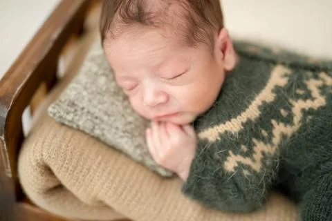 Newborn on tiny bed Stock Photos