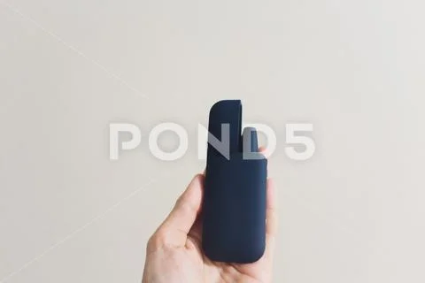 Newest electronic cigarettes, heating tobacco system IQOS, smoking, dark blue Stock Photos