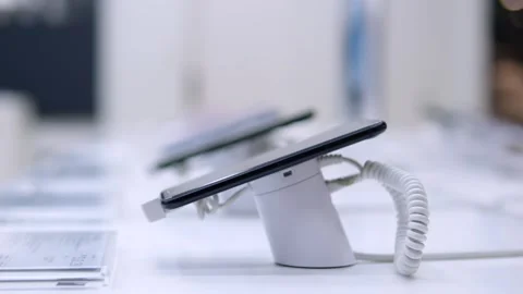 Newest model smartphone is on display in modern electronics store. Ultra-modern Stock Footage 257573269