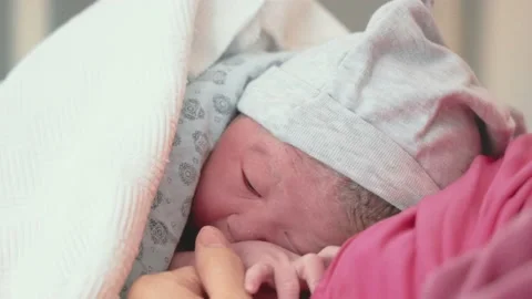 Newly born baby lies on his mother after delivery Stock Footage