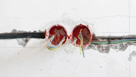 Newly chiseled wall conduits with installed electrical wiring Stock Footage 339298337