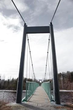 Newly painted, old cable-stayed bridge over a small river Stock Photos