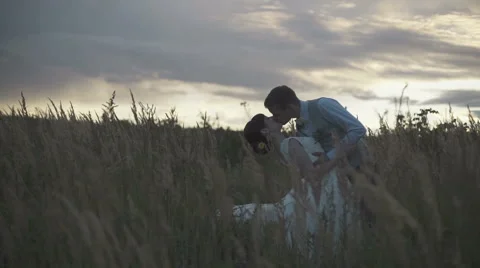 Newlyweds in a field at sunset Stock Footage 63602486