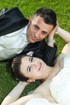 Newlyweds on grass looking at camera Stock Photos