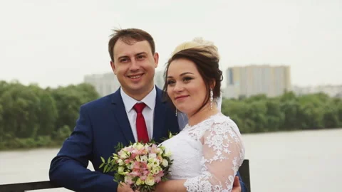 Newlyweds pose in front of the river Stock Footage 106354111