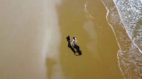 Newlyweds walking down the beach and preforming a twirl Stock Footage 178791906