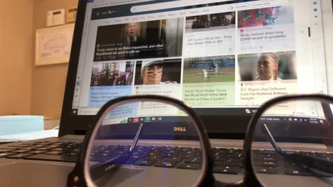 News Scroll search on Laptop, Internet Web, Reading Glasses in Foreground Stock Footage 247011853