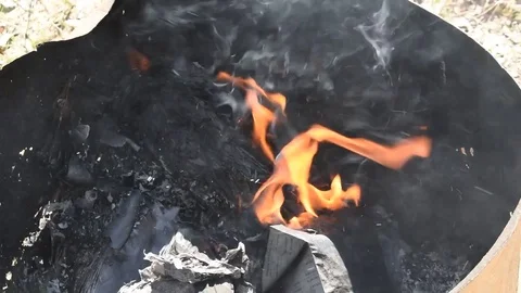 Newspaper burning in fire pit Stock Footage 76377482