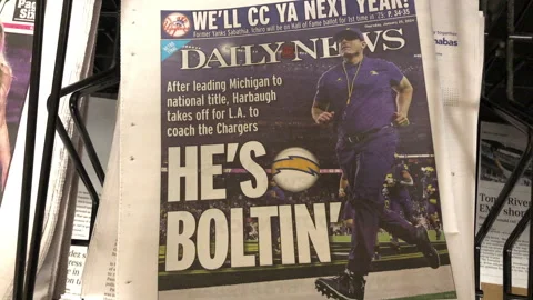 Newspaper Coverage of Jim Harbaugh returning to NFL to coach Chargers Stock Footage 262934759
