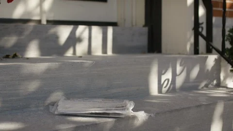Newspaper lands on sunny stoop. Video stock 102789447