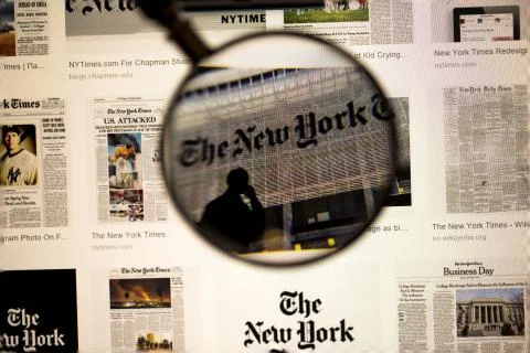 Newspaper title close up view under magnifying glass on computer screen. Foto stock