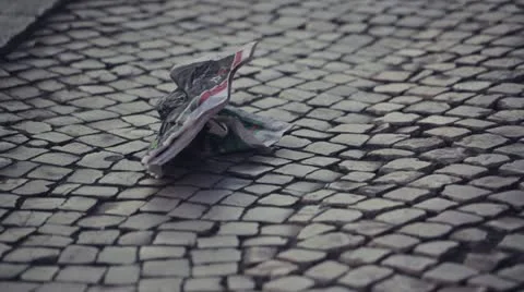 Newspaper trash on cobble Stock Footage 10881418