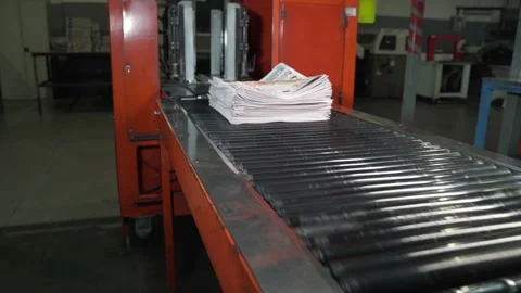 Newspapers fall into large pile and move along the conveyor line. Printing house Stock Footage 171566264