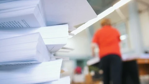 Newspapers in stacks in front of female worker sorting papers in the typography Stock Footage 89665282