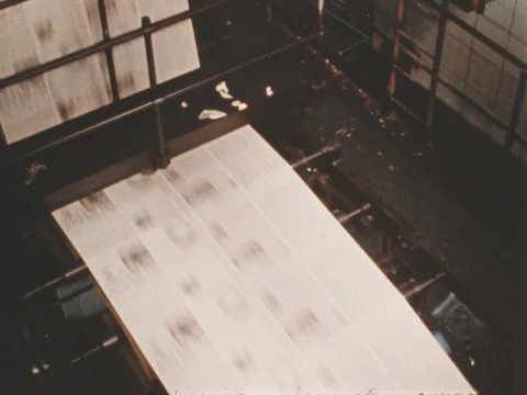Newsprint is fed through the rollers to print newspaper pages. Stock Footage 74398093