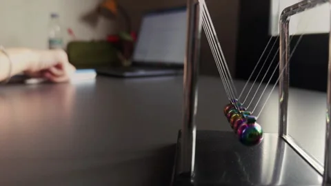 The Newtons Cradle and Studying on Laptop Stock Footage 308883608