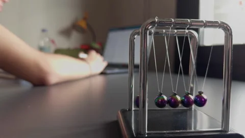 The Newtons Cradle and Studying on Laptop Stock Footage 308883910