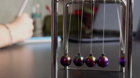 The Newtons Cradle and Studying on Laptop Stock Footage 308884834