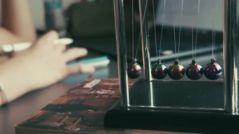 The Newtons Cradle and Studying on Laptop Stock Footage 308884883