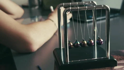 The Newtons Cradle and Studying on Laptop Stock Footage 308886195